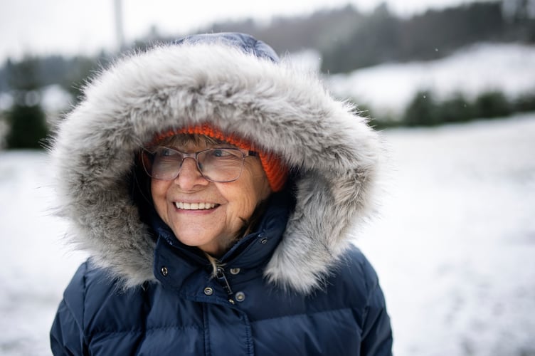 Senior woman hiking on a winter day. The woman is wearing a warm jacket with fake fur hood.
Shot with Canon R5.