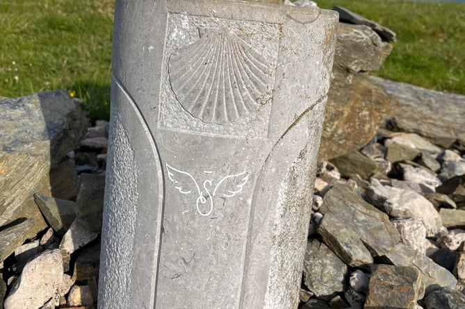 way marker with the pilgrim's symbol - a scallop shell