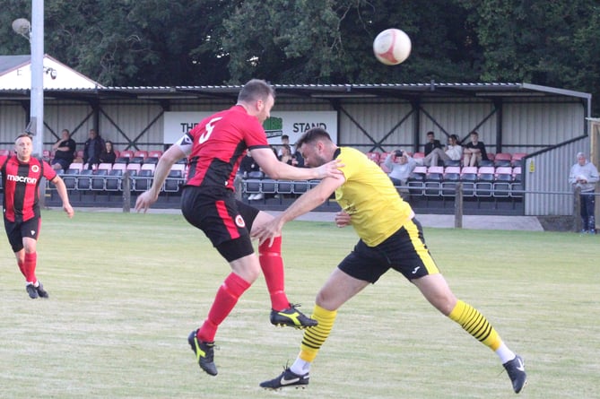 Heads you win as a goitre player beats an Undy opponent to the ball