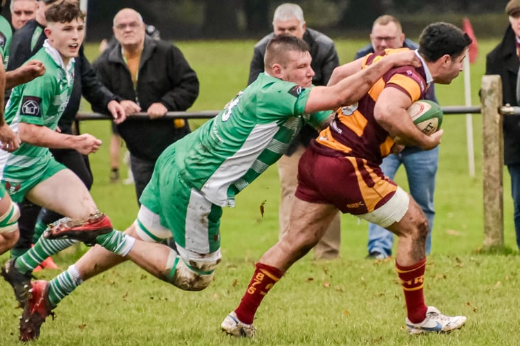 An Abergavenny player tries to break free of the Green Army's shackles